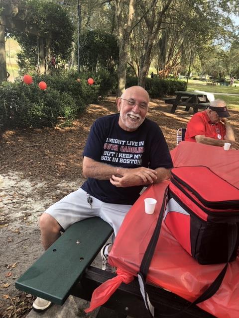 Alves sitting at a picnic table with Red Sox shirt