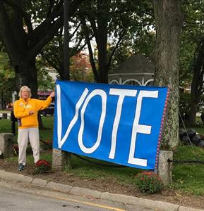 D'Vorah Kelley beside "Vote" sign